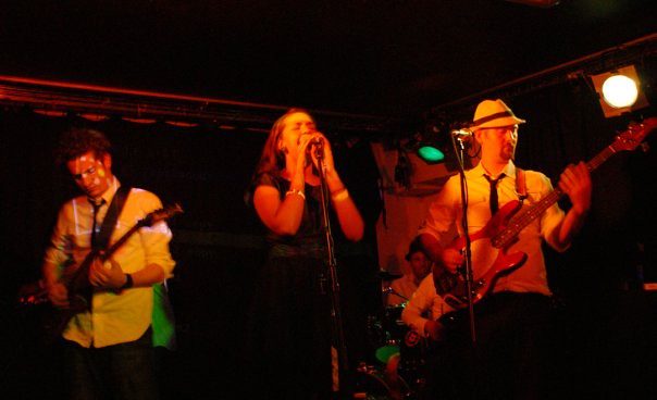 Singer and band in warm club light
