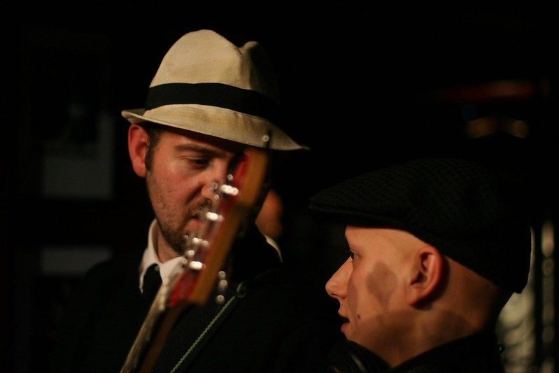Two band members in hats, mid-conversation