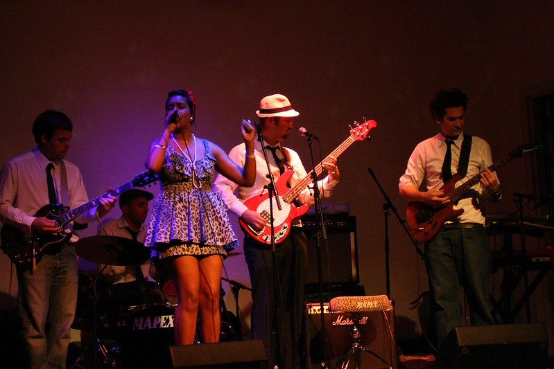 The full band on a purple-lit stage